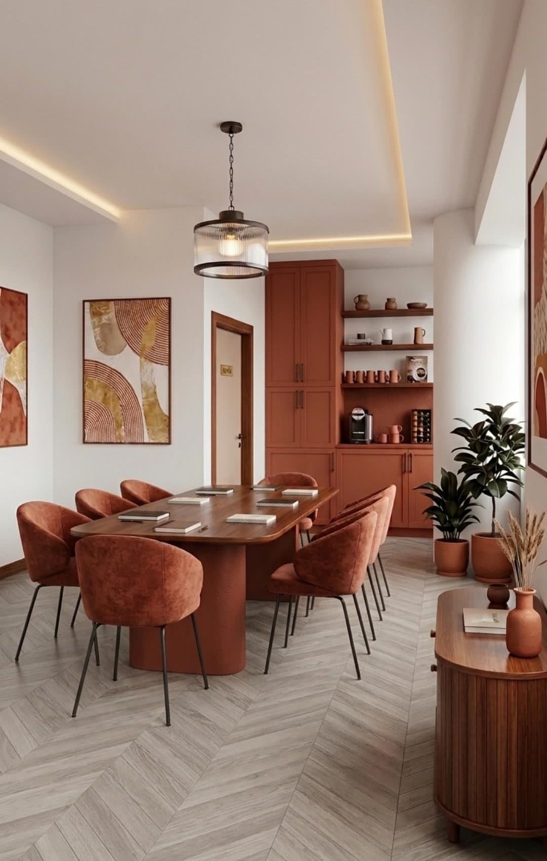 Sala de reuniones con sillas tapizadas en terracota, mesa de madera, mueble de café en tono barro y suelo de espiga gris.